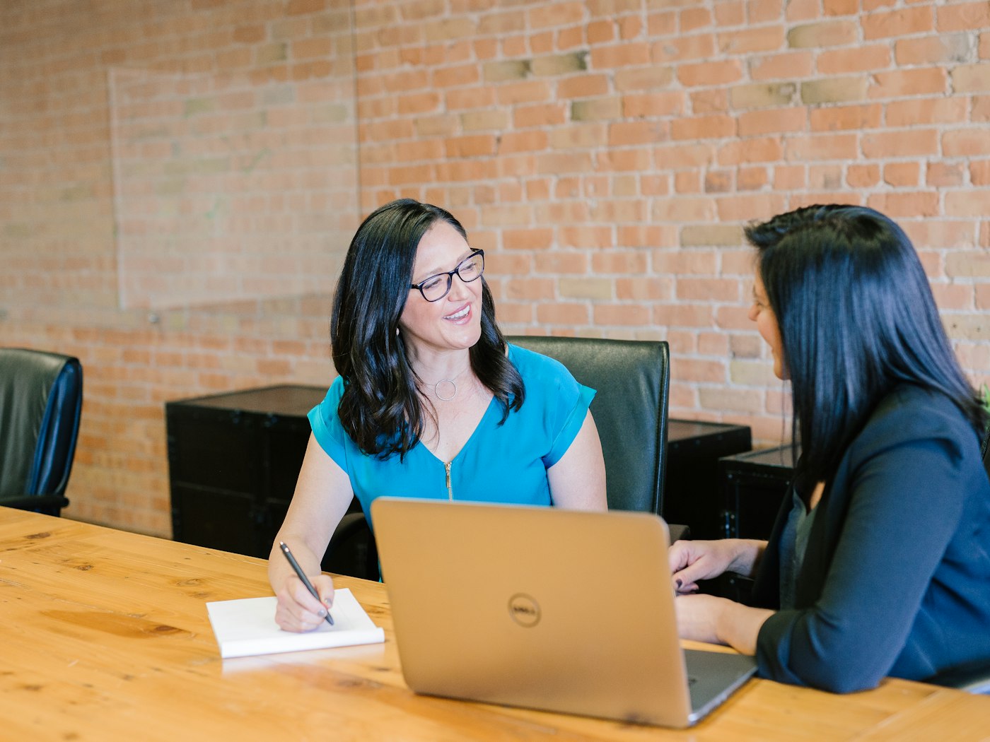 Two colleagues discussing payroll and compensation in a professional meeting