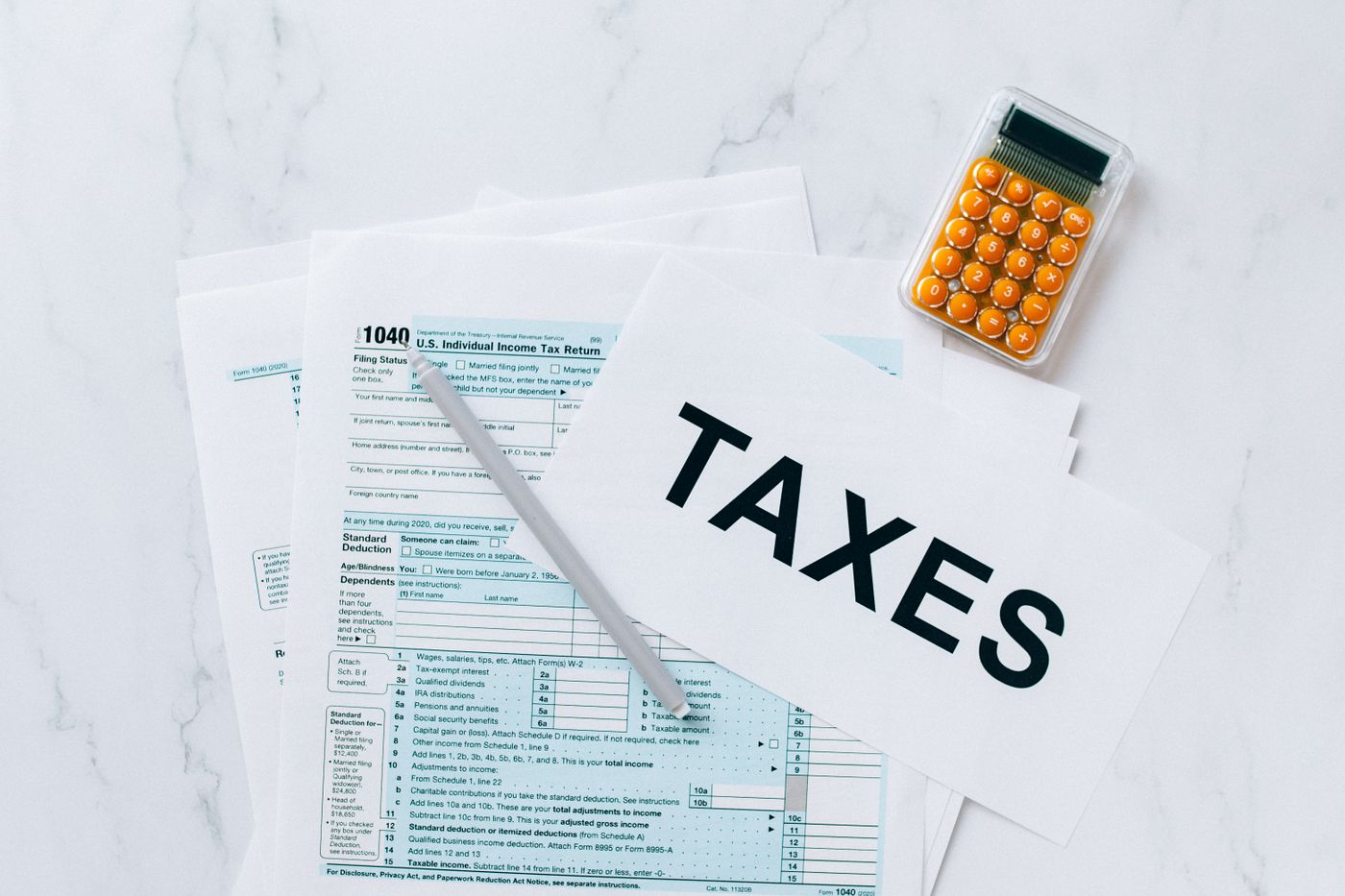 U.S. individual income tax return forms with a calculator and pen